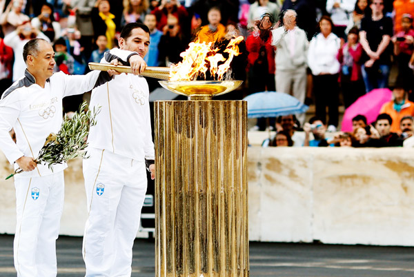 李宁与希腊举重运动员迪马斯在5月17日的伦敦奥运圣火交接仪式上共同点燃圣火台瞬间